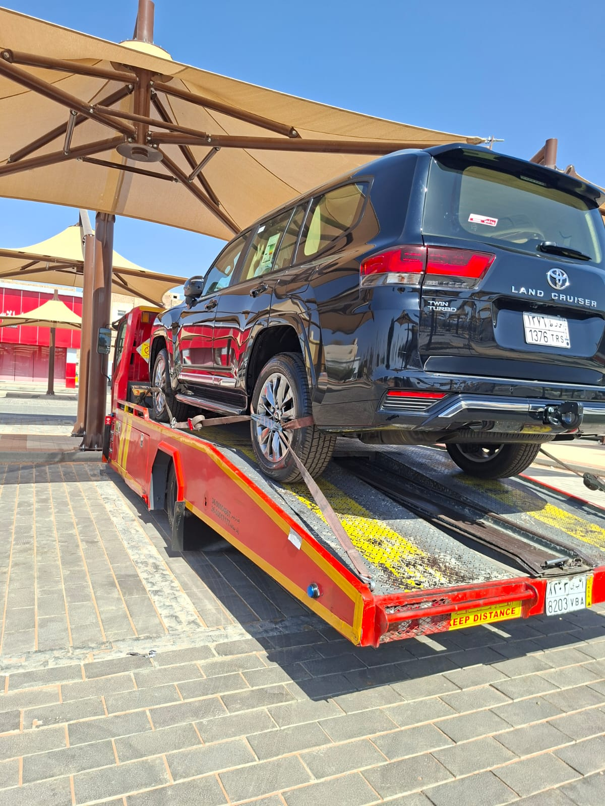 سطحة هيدروليك حمراء تنقل سيارة BMW فاخرة في الدمام
